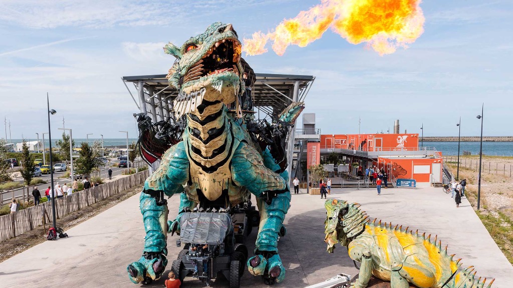 Le Dragon de Calais crachant sa flamme sur le parvis de la Cité du Dragon à Calais